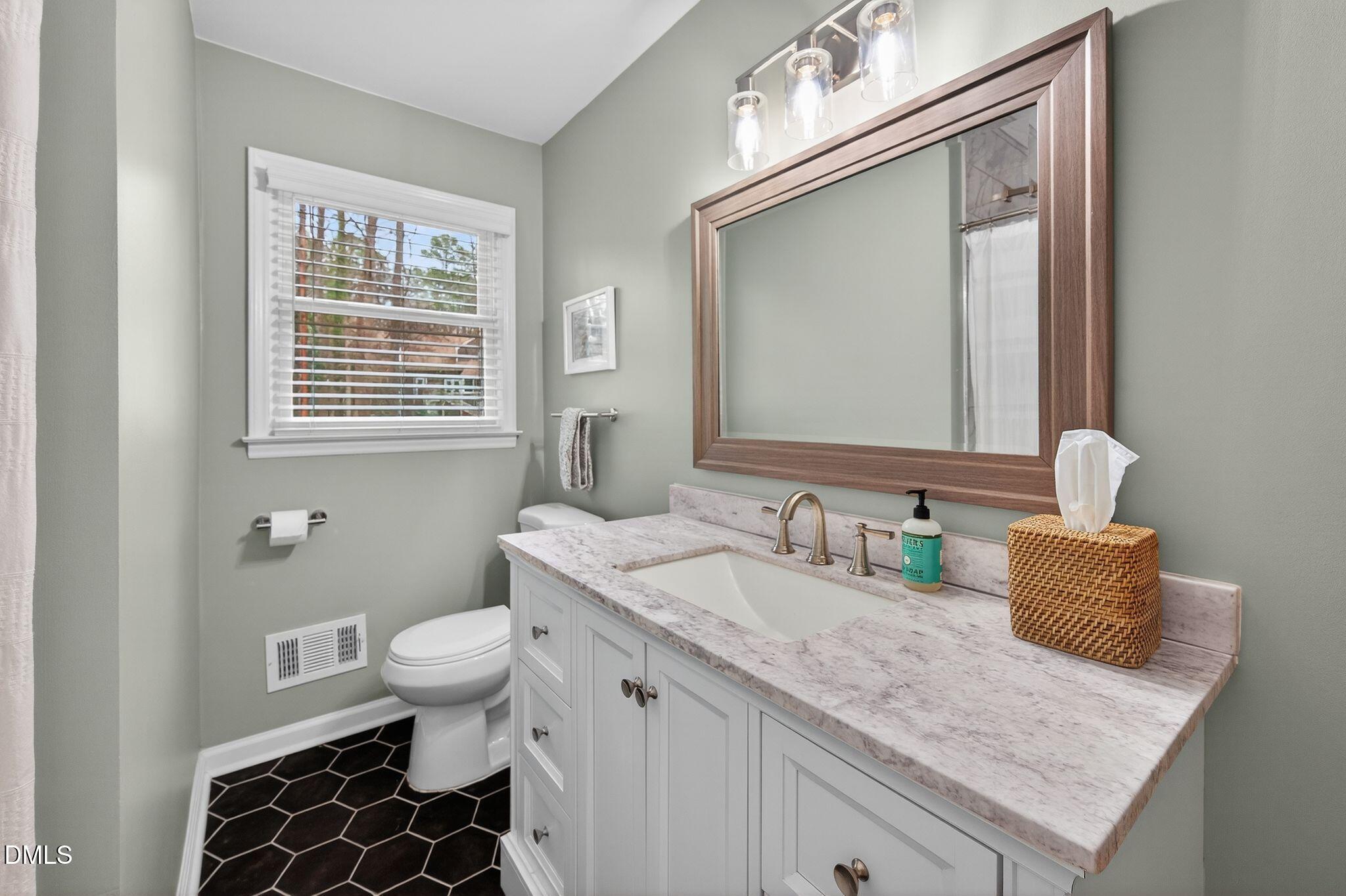 5620 Old Forge Circle Raleigh, NC 27609 - Photo 31 of 46 a bathroom with a granite countertop sink a toilet and a mirror