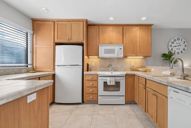 a kitchen with a refrigerator sink and cabinets