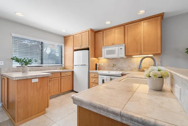 a kitchen with stainless steel appliances granite countertop a stove a sink a refrigerator and a microwave