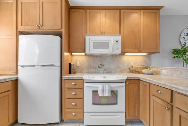 a kitchen with a refrigerator sink and cabinets