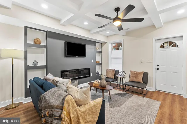 a living room with furniture a fireplace and a flat screen tv