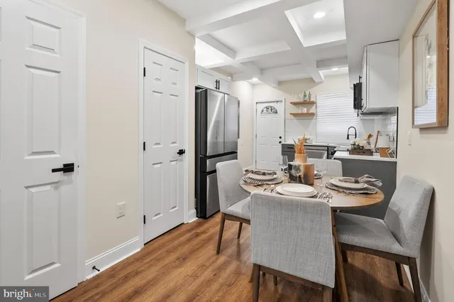 a kitchen with stainless steel appliances a refrigerator a table and chairs