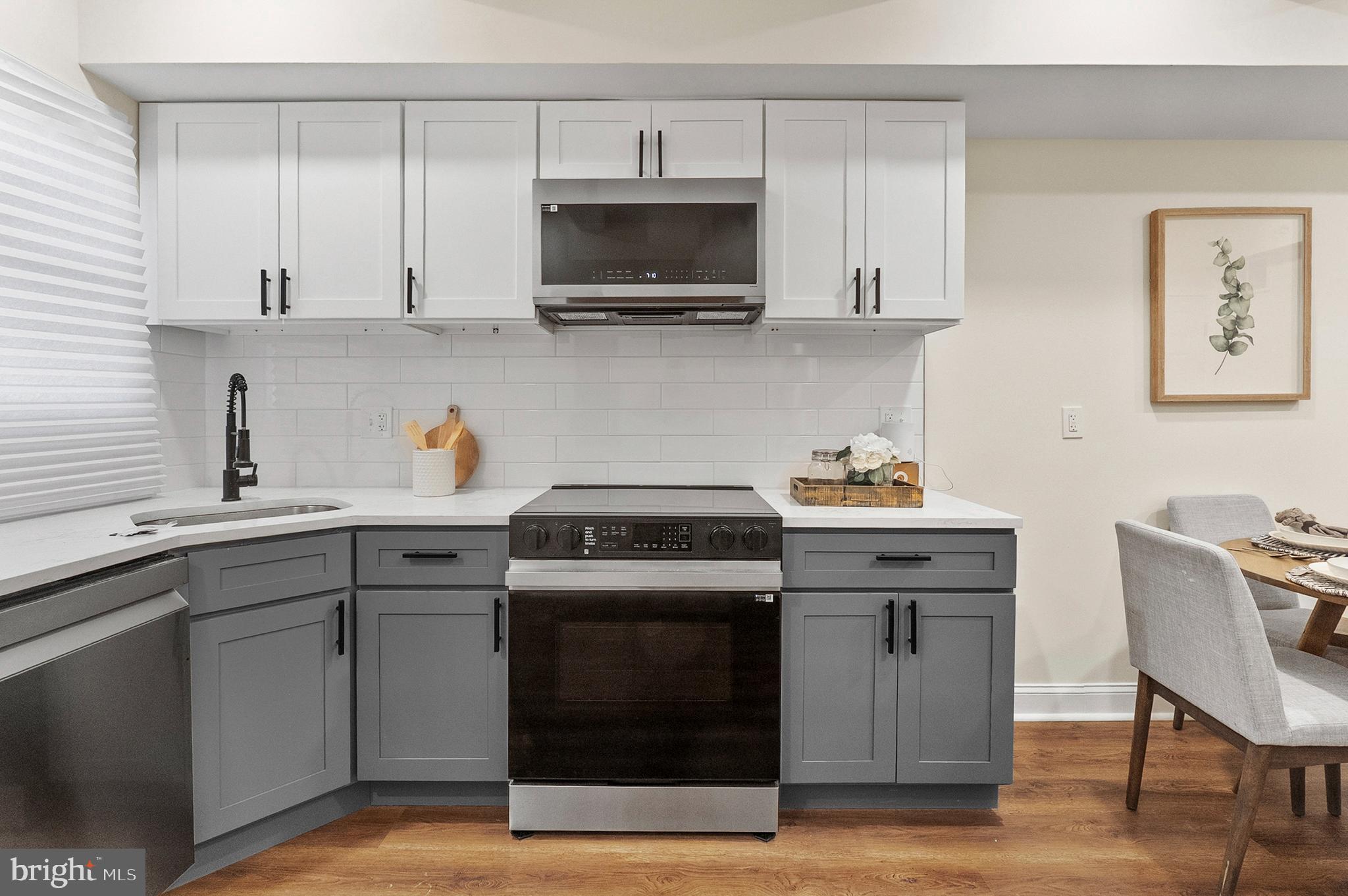 323 South Stricker Street Baltimore, MD 21223 - Photo 12 of 39 a kitchen with cabinets appliances and wooden floor