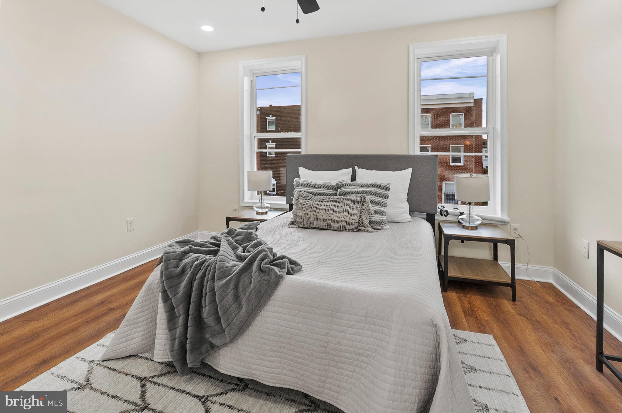 323 South Stricker Street Baltimore, MD 21223 - Photo 18 of 39 a bedroom with a bed and wooden floor