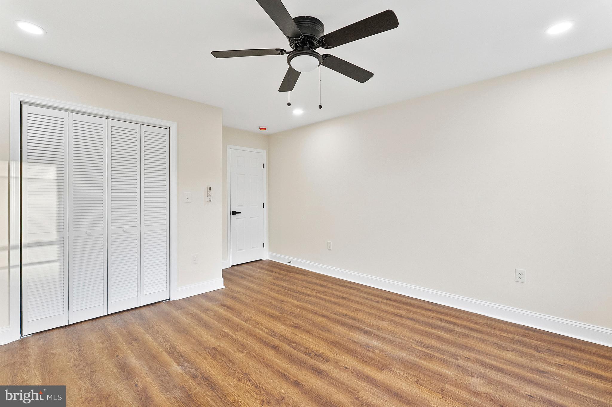 323 South Stricker Street Baltimore, MD 21223 - Photo 26 of 39 an empty room with wooden floor ceiling fan and windows