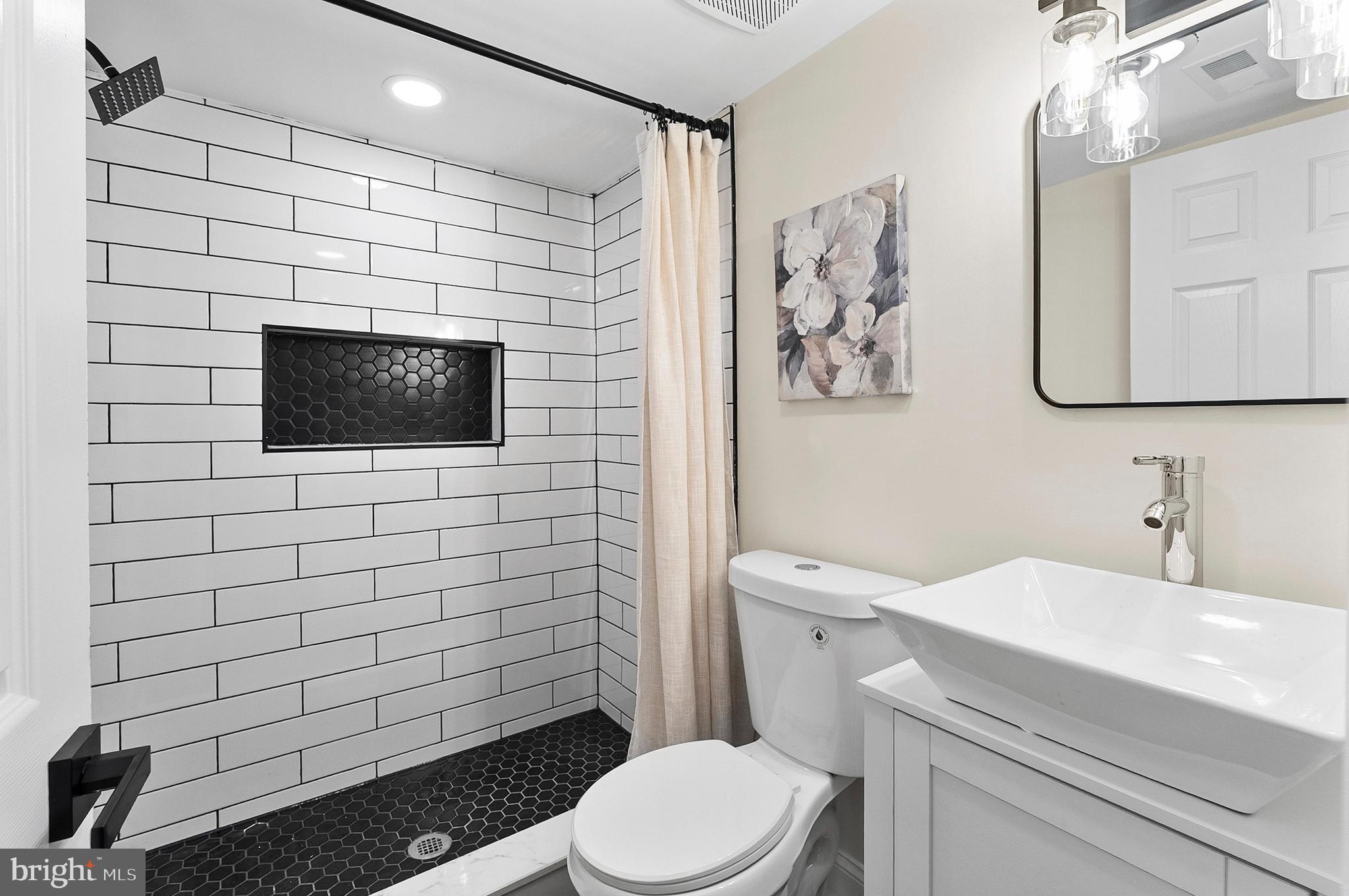 323 South Stricker Street Baltimore, MD 21223 - Photo 31 of 39 a bathroom with a toilet sink and mirror