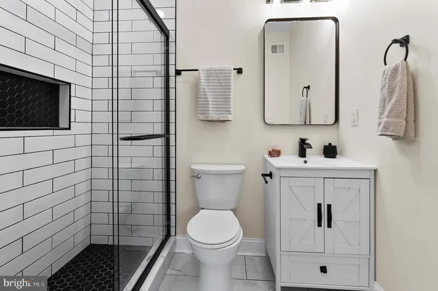 a bathroom with a toilet sink vanity and mirror