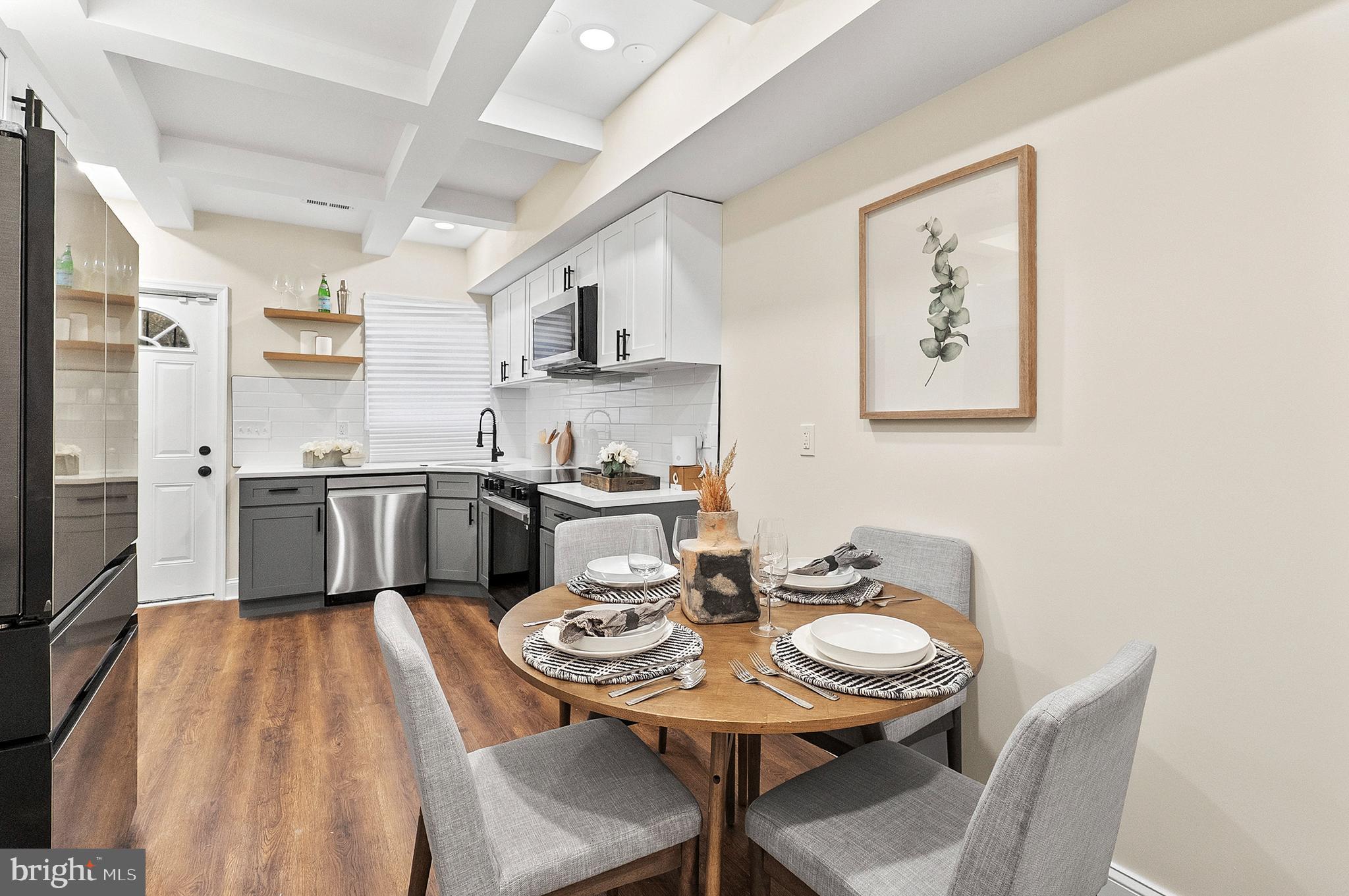 323 South Stricker Street Baltimore, MD 21223 - Photo 5 of 39 a kitchen with stainless steel appliances a dining table and chairs