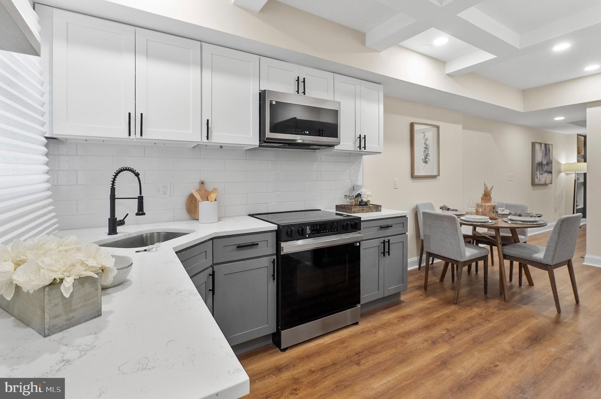 323 South Stricker Street Baltimore, MD 21223 - Photo 6 of 39 a kitchen with stainless steel appliances a white stove top oven a sink dishwasher and white cabinets