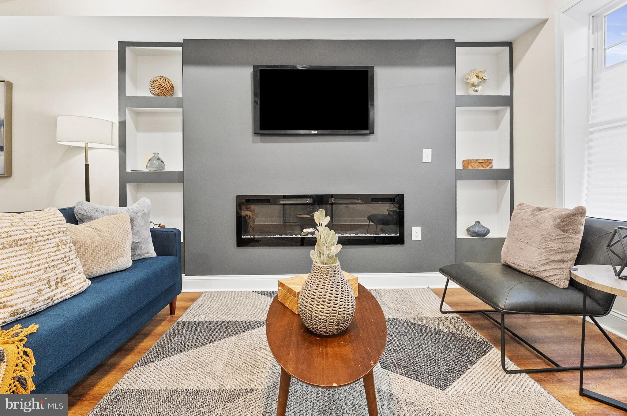 323 South Stricker Street Baltimore, MD 21223 - Photo 8 of 39 a living room with furniture a flat screen tv and a fireplace