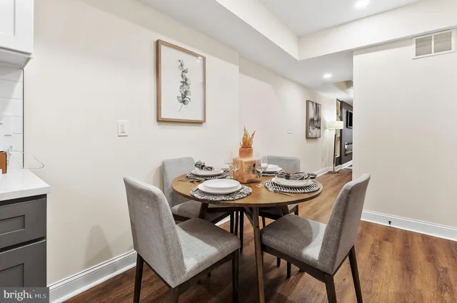 a dining room with stainless steel appliances kitchen island granite countertop furniture and wooden floor