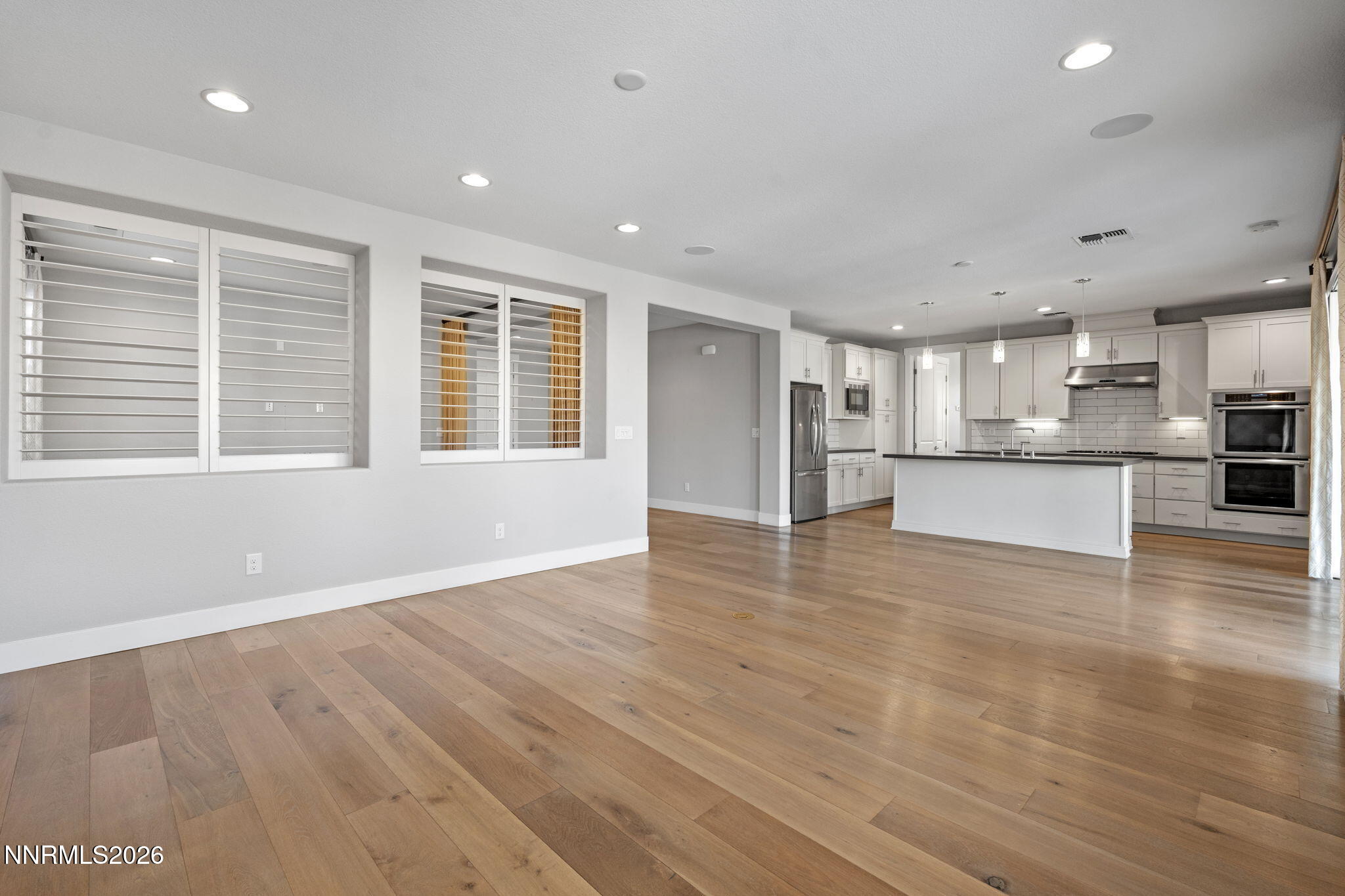 9785 Hafflinger Lane Reno, NV 89521 - Photo 11 of 34 a view of an empty room with a window and wooden floor