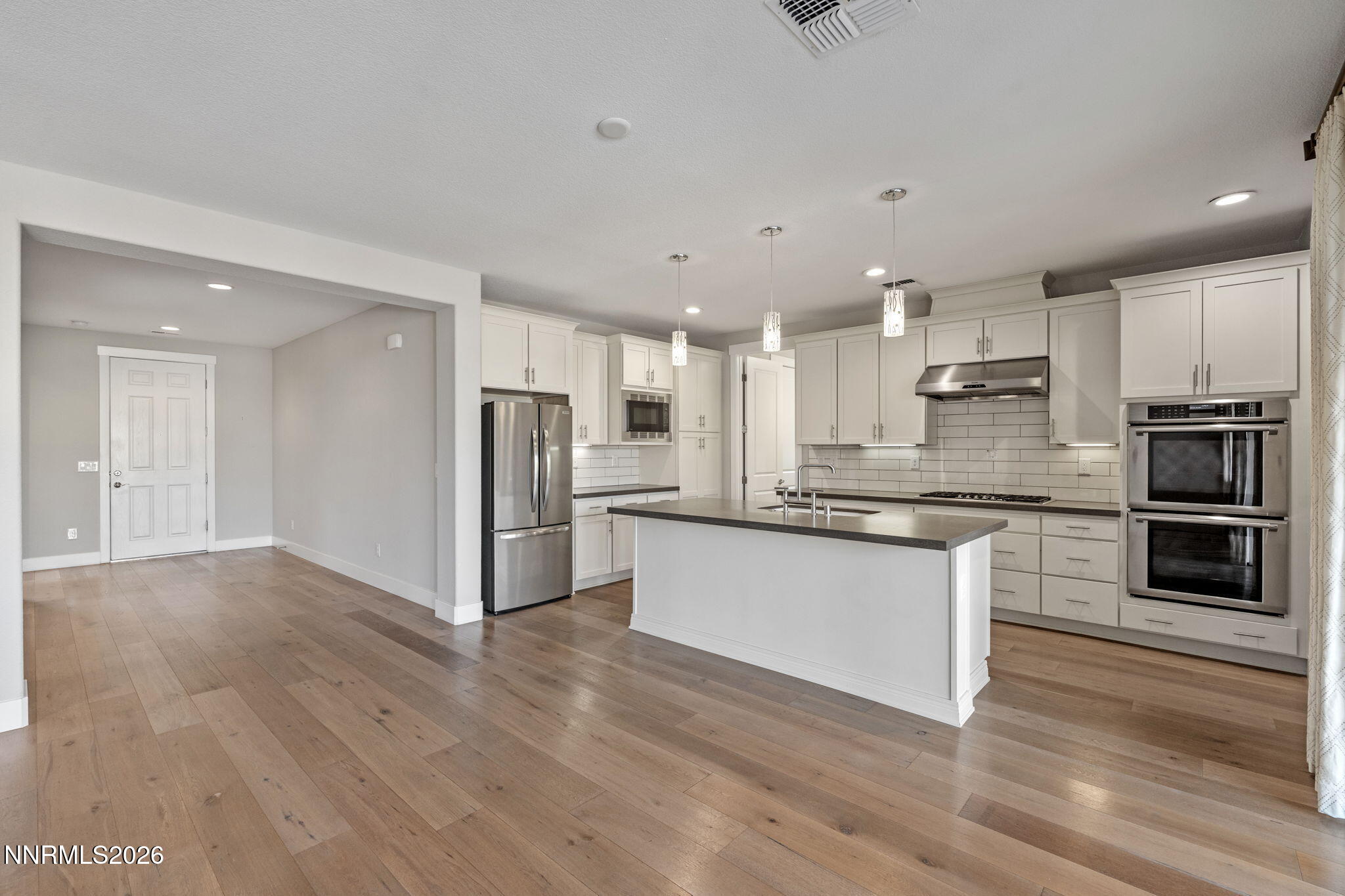 9785 Hafflinger Lane Reno, NV 89521 - Photo 16 of 34 a kitchen with stainless steel appliances kitchen island granite countertop a stove a sink and a refrigerator