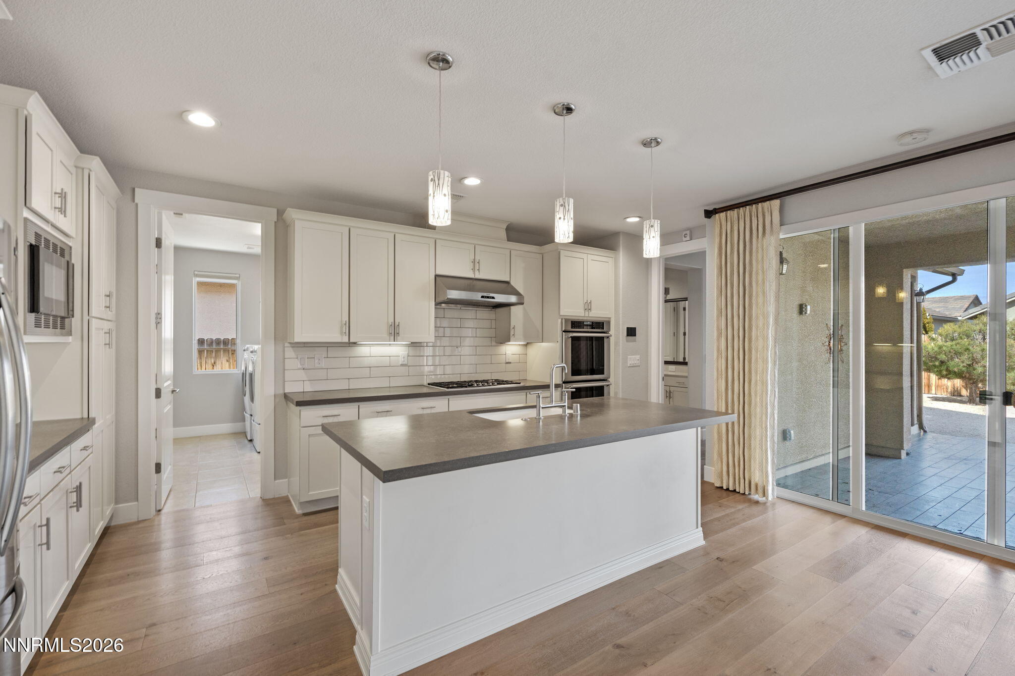 9785 Hafflinger Lane Reno, NV 89521 - Photo 19 of 34 a large kitchen with stainless steel appliances kitchen island a large counter top and a refrigerator