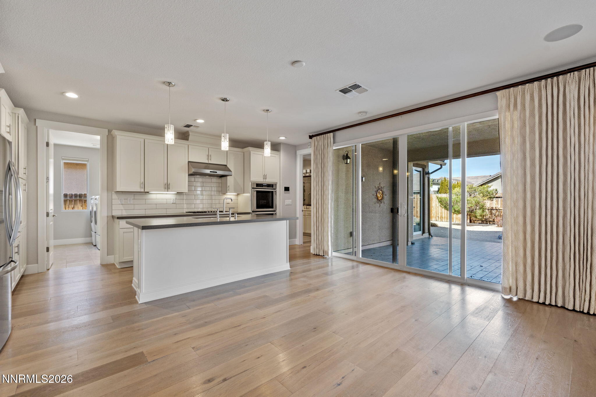 9785 Hafflinger Lane Reno, NV 89521 - Photo 20 of 34 a large kitchen with large windows and wooden floor