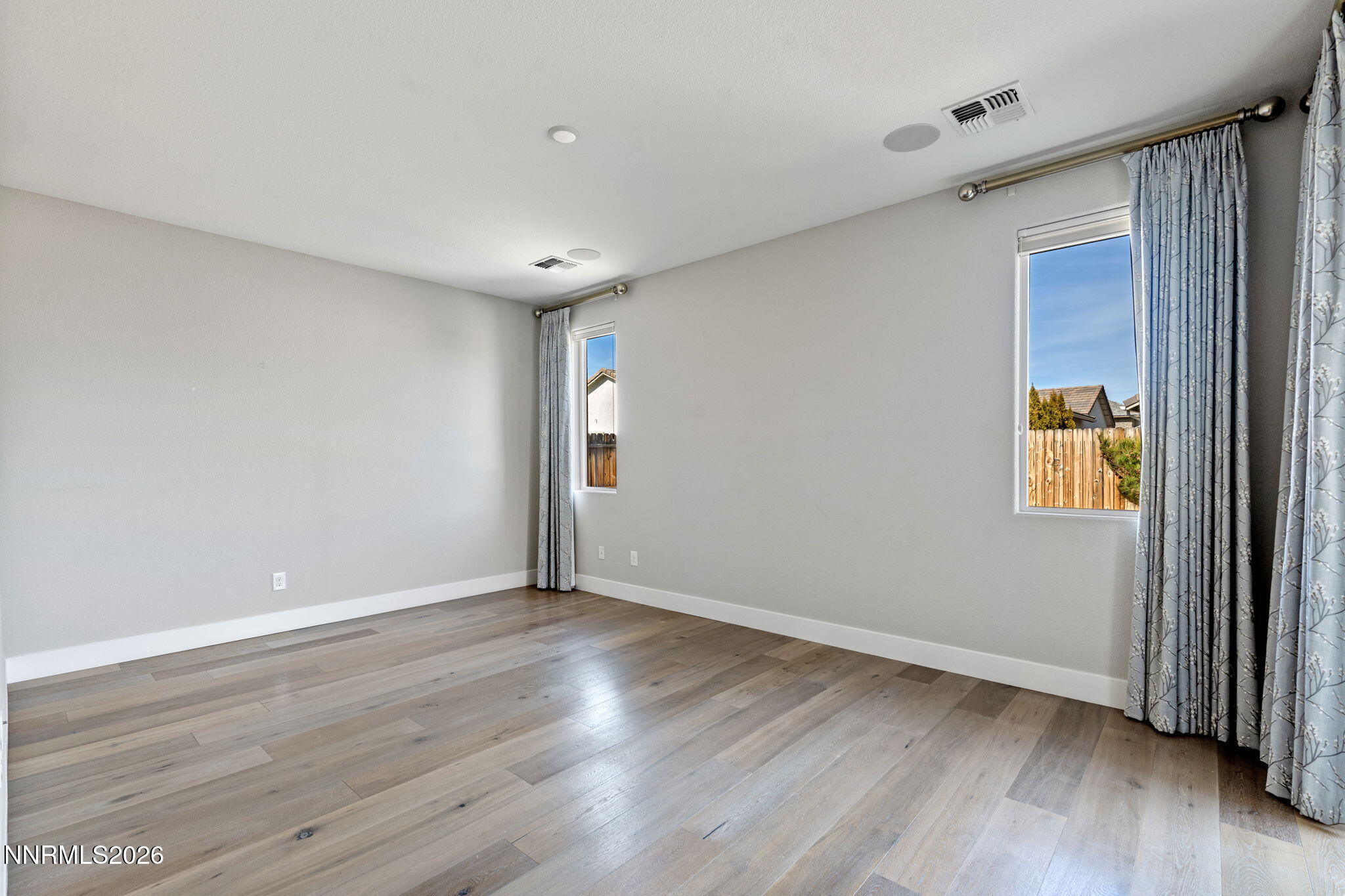 9785 Hafflinger Lane Reno, NV 89521 - Photo 22 of 34 a view of an empty room with wooden floor and a window