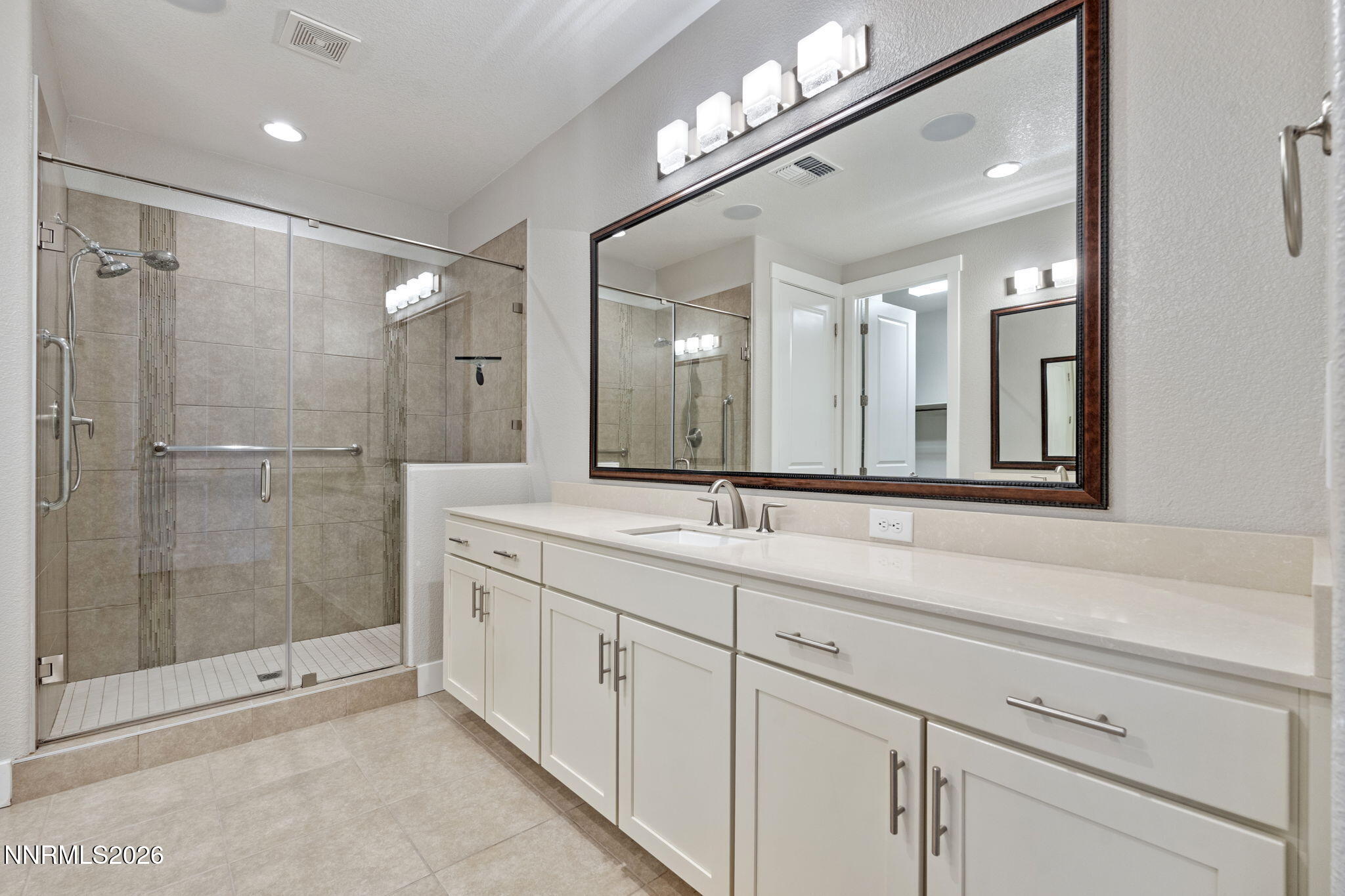 9785 Hafflinger Lane Reno, NV 89521 - Photo 24 of 34 a bathroom with a shower sink and mirror