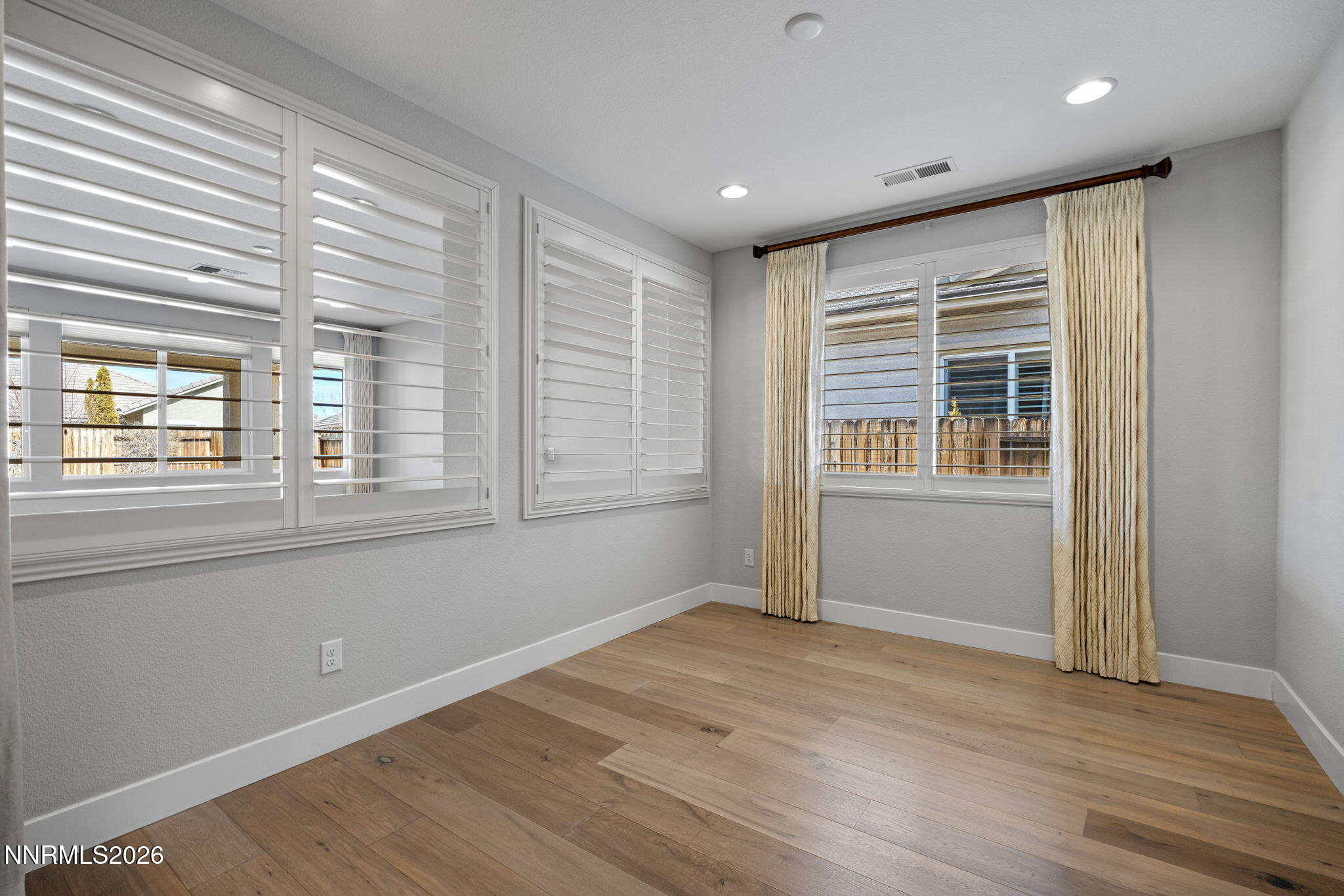 9785 Hafflinger Lane Reno, NV 89521 - Photo 7 of 34 a view of an empty room with wooden floor and a window