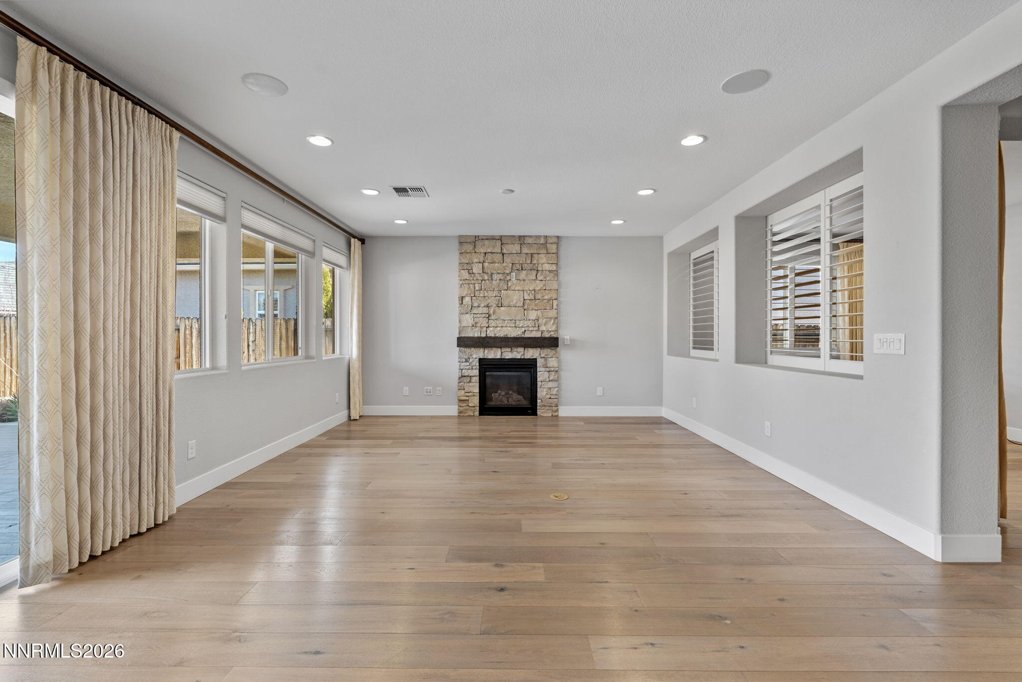 9785 Hafflinger Lane Reno, NV 89521 - Photo 9 of 34 a view of an empty room with a window and fireplace