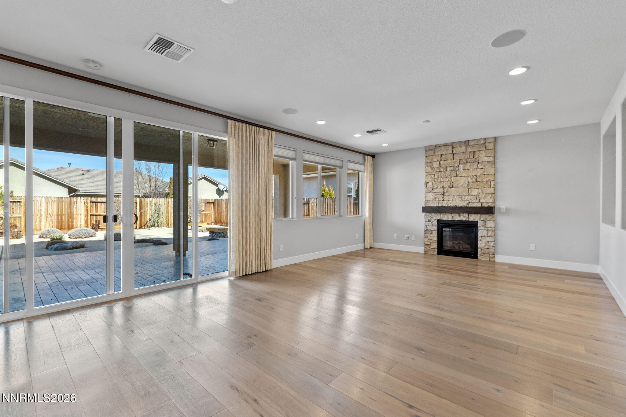 9785 Hafflinger Lane Reno, NV 89521 - Photo 10 of 34 an empty room with wooden floor and fireplace