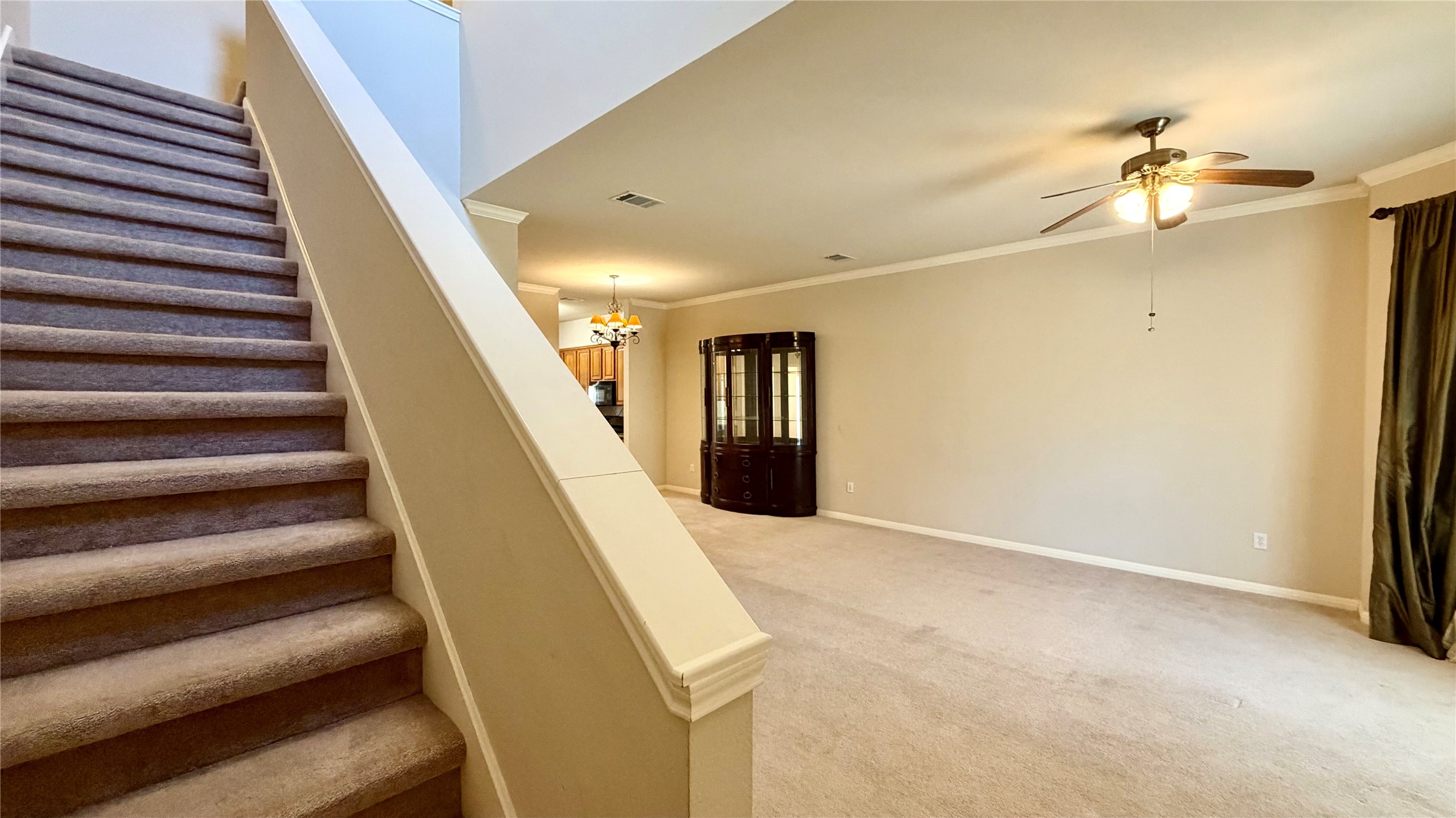 5515 Davis Lane, Unit 82 Austin, TX 78749 - Photo 17 of 28 View of Great Room with Stairway to second floor featuring crown molding, carpet, and a ceiling fan.