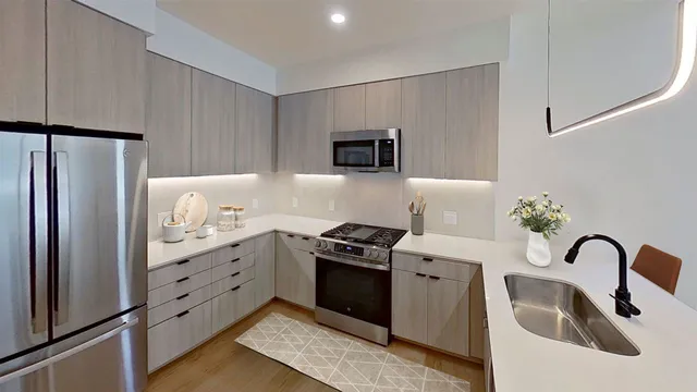 a kitchen with granite countertop a refrigerator and a stove top oven