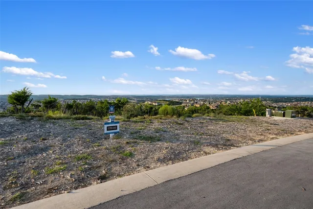 a view of a yard with wooden fence
