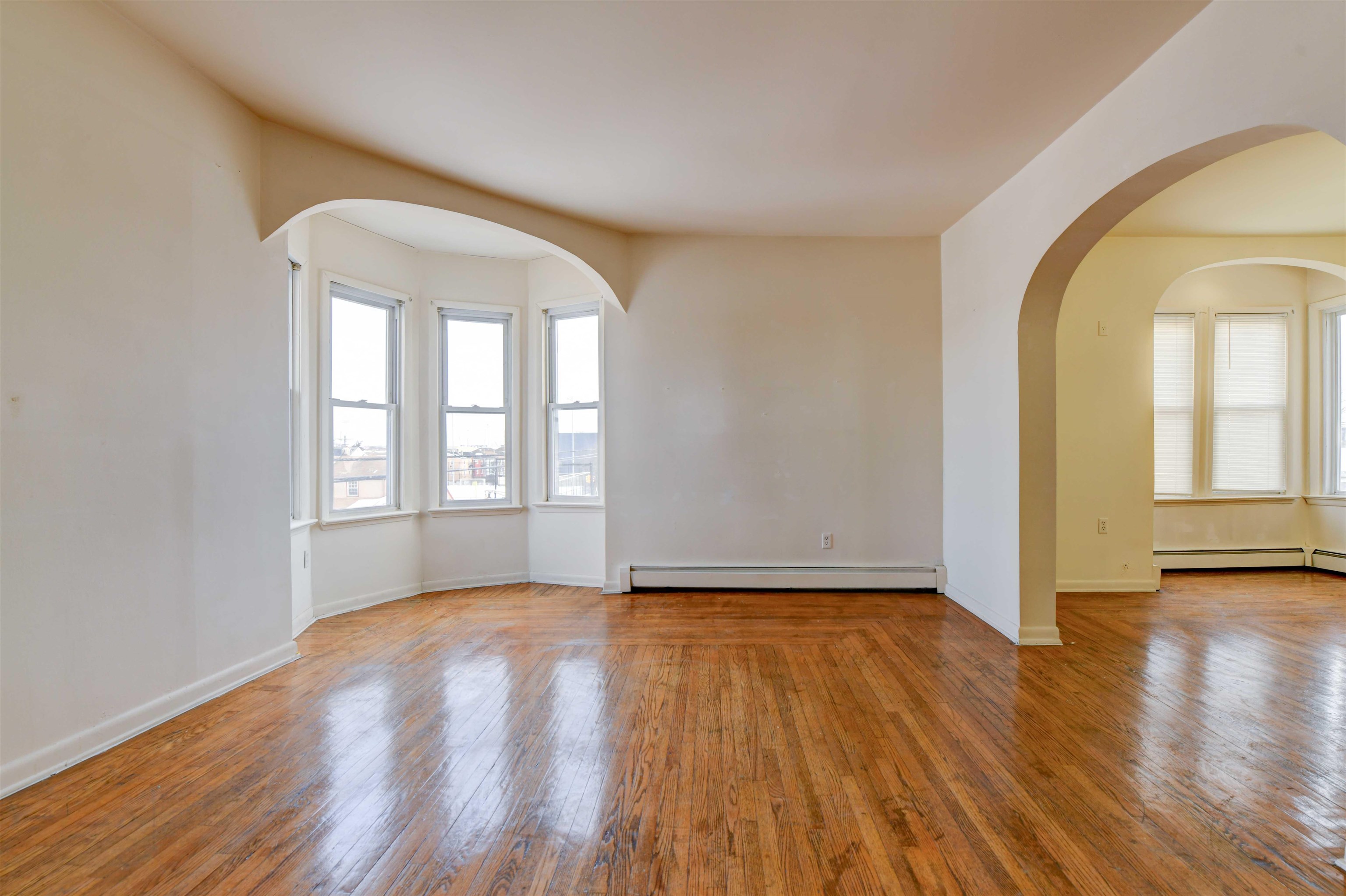 625 Harrison Avenue, Unit 2 Harrison, NJ 07029 - Photo 22 of 25 an empty room with wooden floor and windows