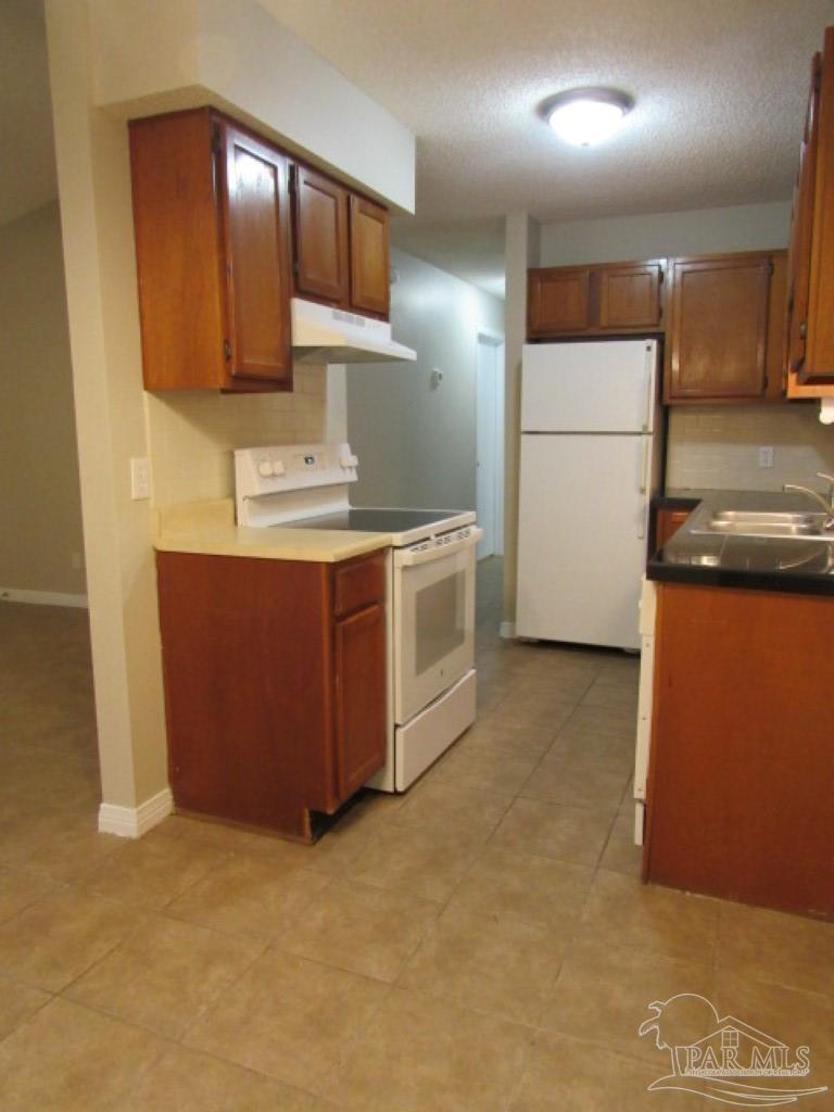 3322 Pine Forest Road Cantonment, FL 32533 - Photo 4 of 9 a kitchen with stainless steel appliances granite countertop a stove a refrigerator and a microwave