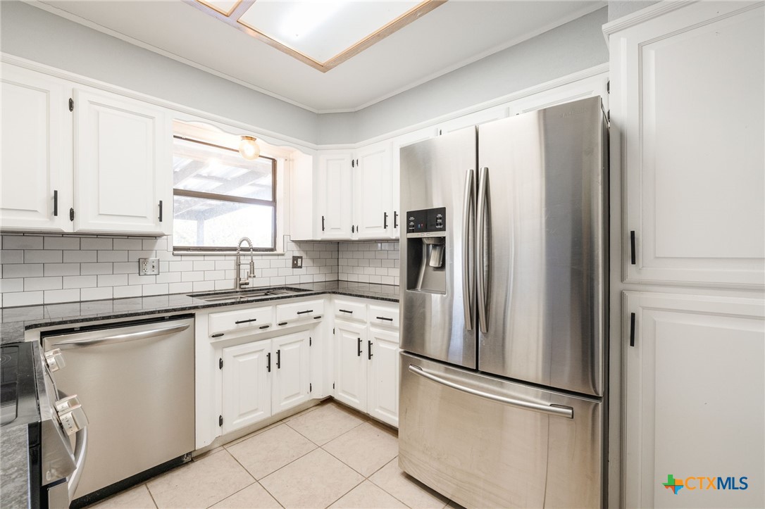 554 County Road 4707 Kempner, TX 76539 - Photo 9 of 33 a kitchen with white cabinets and stainless steel appliances