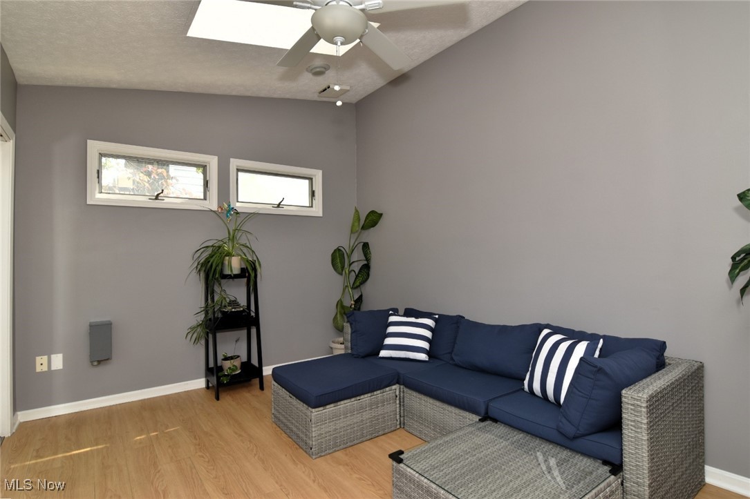 3679 Fenley Road Cleveland Heights, OH 44121 - Photo 21 of 45 Sitting room with light wood-style floors, lofted ceiling, a ceiling fan, a skylight, and a textured ceiling