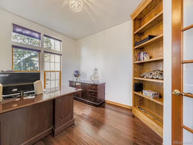 a dining room with furniture a chandelier and wooden floor
