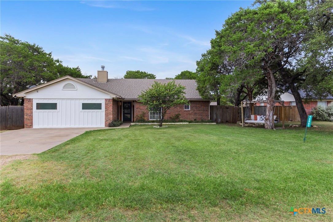 a front view of a house with a garden and trees