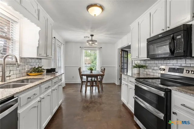a kitchen with stainless steel appliances stove microwave and cabinets
