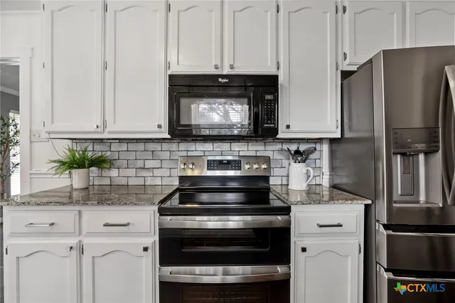 a kitchen with stainless steel appliances a stove microwave and cabinets