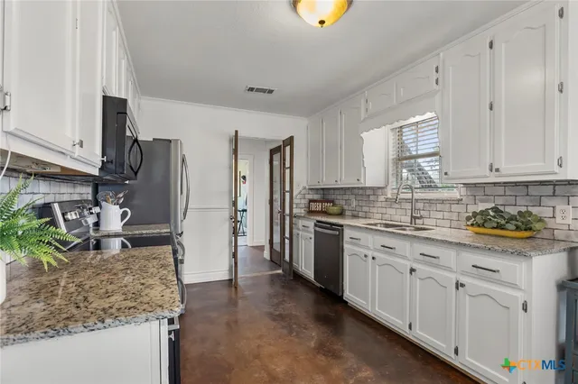 a kitchen with stainless steel appliances granite countertop a sink stove and refrigerator