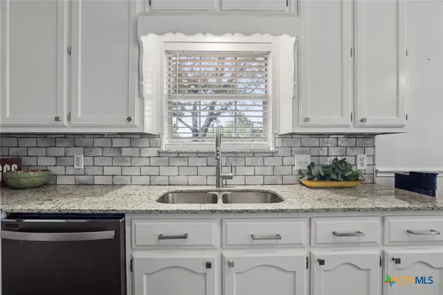 a kitchen with sink cabinets and window