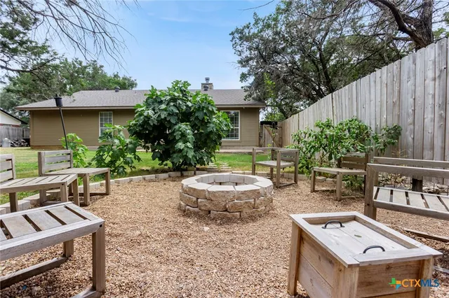 a backyard of a house with fountain table and chairs