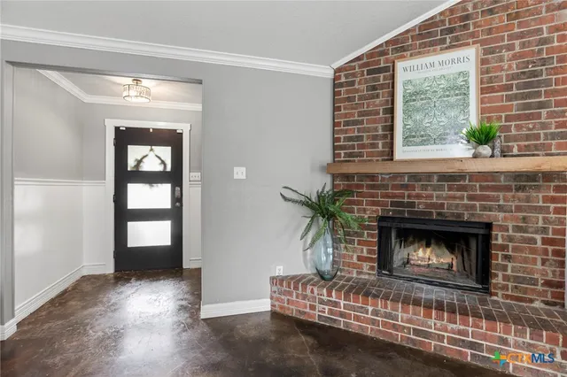 a living room with a fireplace and windows