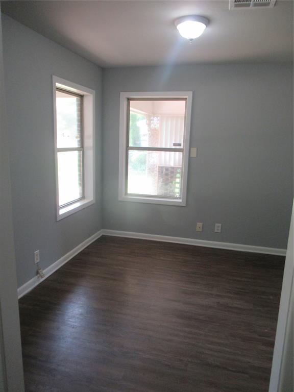2513 Rosedale Place Bossier City, LA 71111 - Photo 5 of 13 Room featuring two windows, wood-finish flooring, light gray wall paint, white baseboards, and a ceiling-mounted light fixture