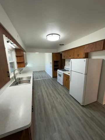 a kitchen with wooden floor and electronic appliances