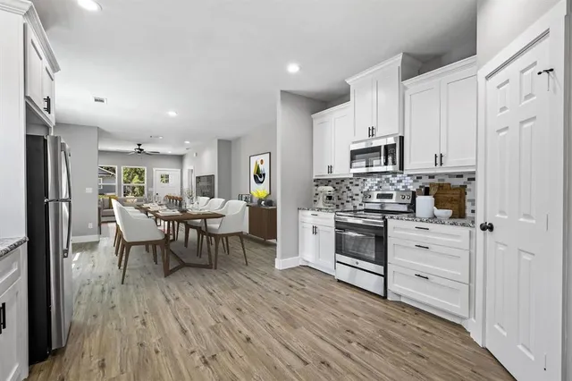 a kitchen with white cabinets and stainless steel appliances