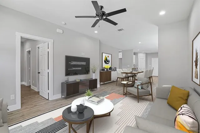 a living room with furniture kitchen view and a flat screen tv