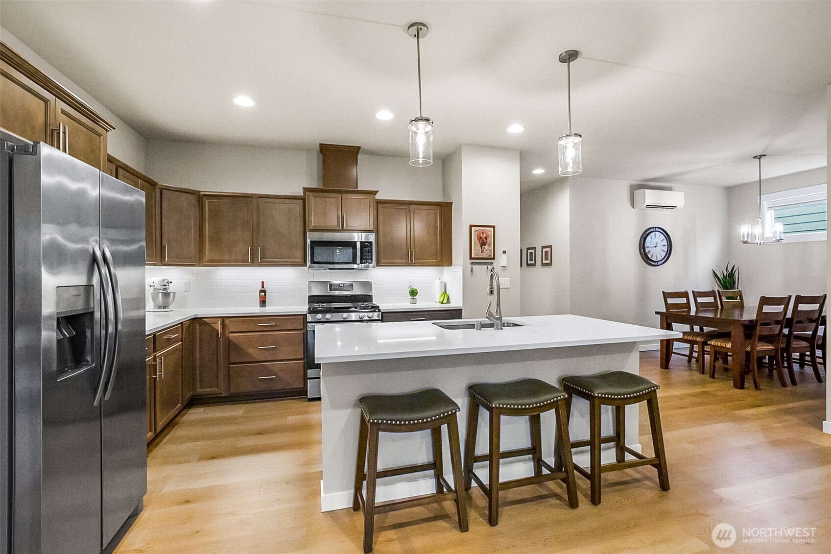 772 Parkland Loop Sedro-Woolley, WA 98284 - Photo 27 of 40 a kitchen with stainless steel appliances kitchen island granite countertop a dining table chairs refrigerator and microwave