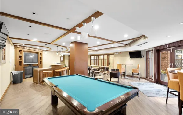 a room with furniture pool table wooden floor and a large window