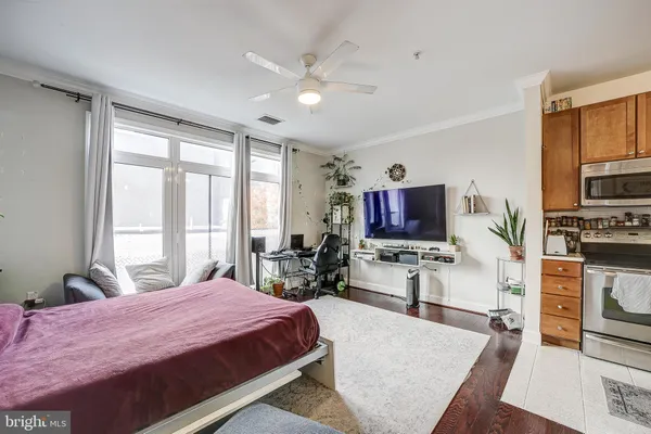 a bedroom with a bed a flat screen tv and windows