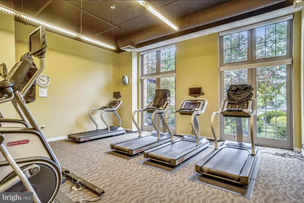 a living room with furniture gym equipment and a large window