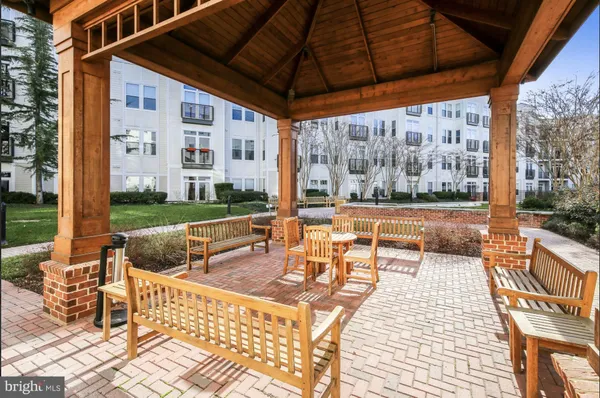 a view of a patio with couches dining table and chairs under an umbrella
