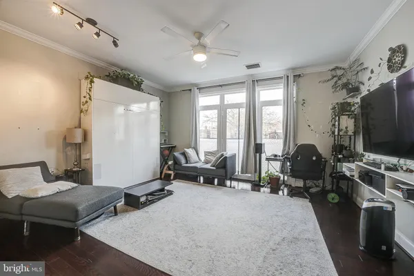 a living room with furniture gym equipment and a large window