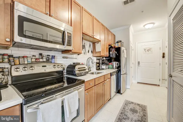 a kitchen with stainless steel appliances a stove a sink and a refrigerator